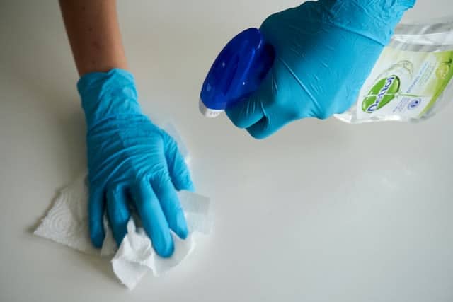 Gloved hands using spray cleaner