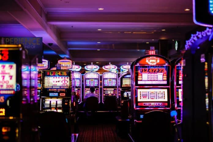 Dimly lit casino floor with slot machines