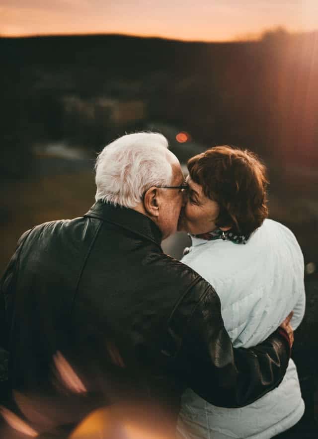 Older couple kissing outdoors