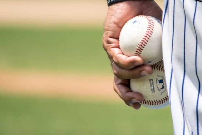 Baseballplayer holding two baseballs in his hand