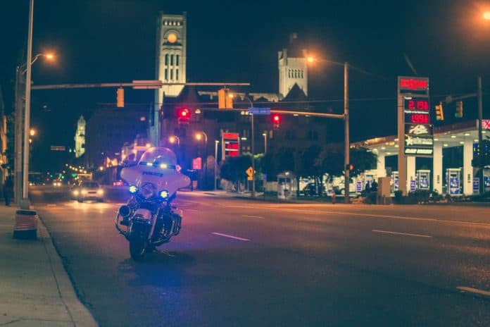 Police motorcycle with lights on at night