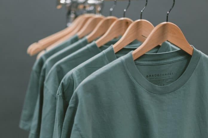 Identical green shirts on hangers, all in a row
