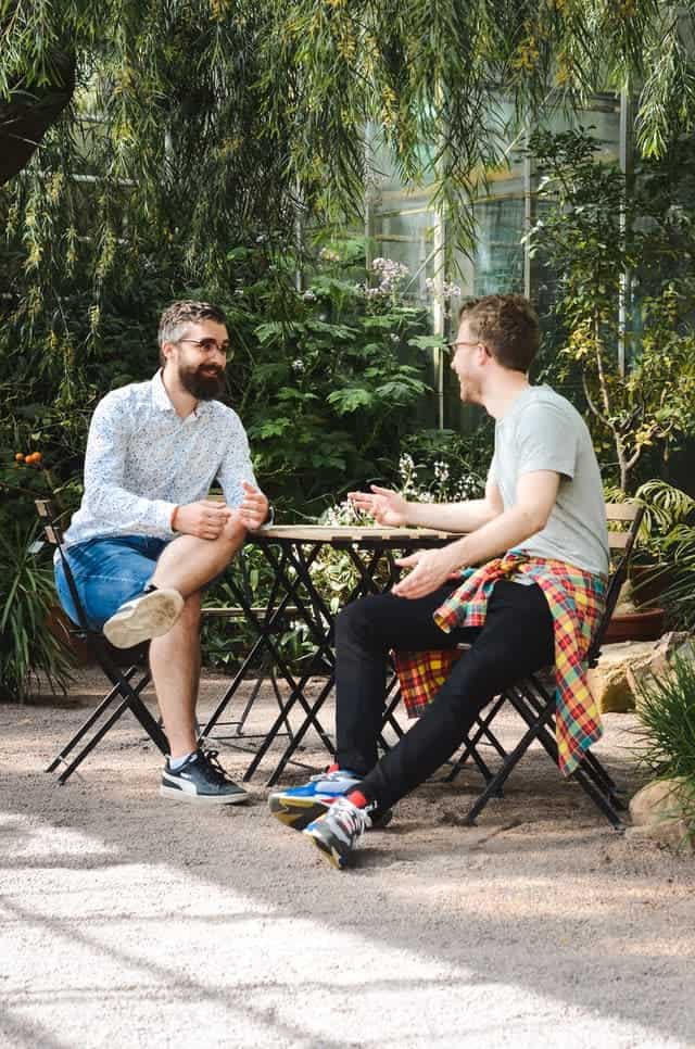 Two men sitting at outside table, chatting