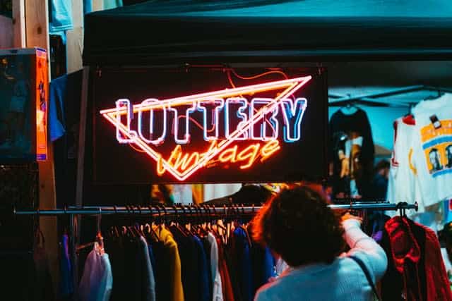 Neon sign for vintage store, with racks of clothes below