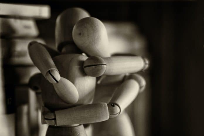 Two wooden figure dolls in an embracec