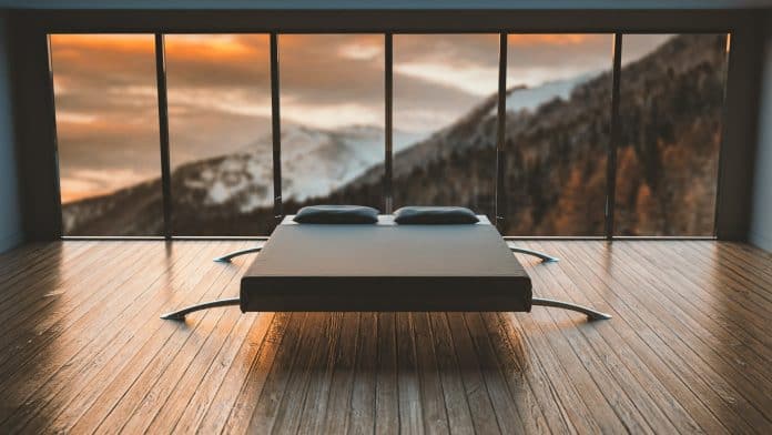 Bed with legs sticking far out the sides, to make it look almost floating. In front of large windows overlooking a mountain range