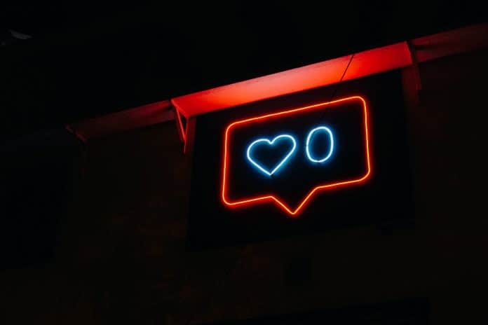 Neon sign in shape of social media notification, showing zero hearts, or interactions with a post