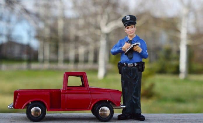 Toy truck and police officier writing a ticket
