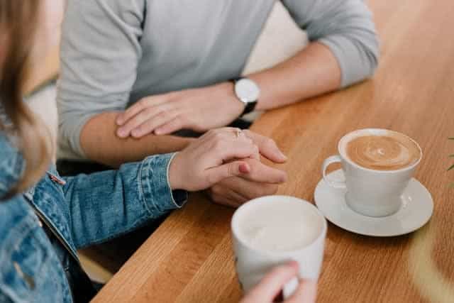 Woman holding man's hand in cafe