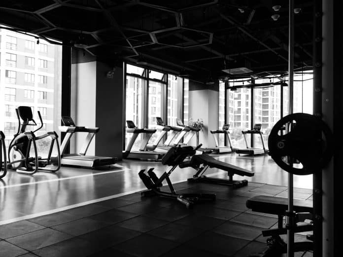 Empty gym with cardio machines at the windows, and weights in the middle