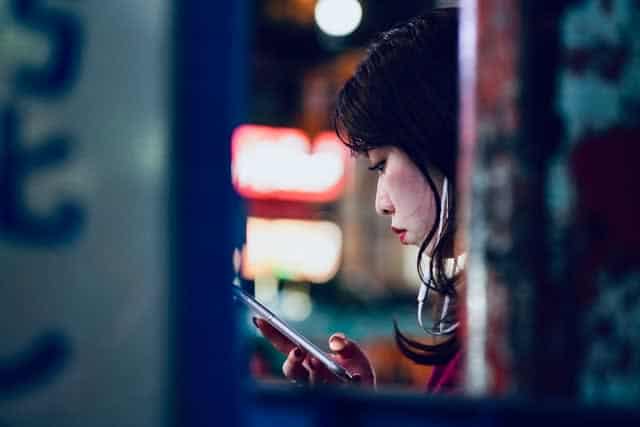 Japanese woman using smart phone with headphones