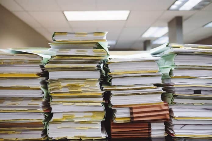 Multiple tall stacks of paperwork